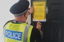 The police closure notice being served on 5 Cedar Grove in Dogsthorpe, Peterborough.