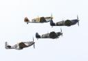 A vintage four of two Spitfires, a Mustang and a Buchon flying in formation at IWM Duxford.