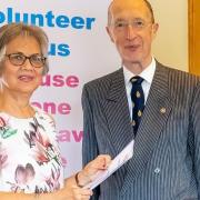 Mercedes receiving certificate of Long Service Award and gold logo pin badge from Deputy Lieutenant, His Honour Neil McKittrick