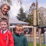 The Duchess of Gloucester with two Brington primary school children planting a commemorative tree.