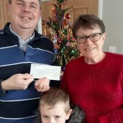 Chatteris Town Councillor James Carney and his son, Noel, handing the 'Poppy on a Lamppost' fundraiser cheque over to Poppy Appeal organiser Lynda Behagg.