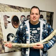 Jamie Jordan with the mammoth tusk found near Peterborough.