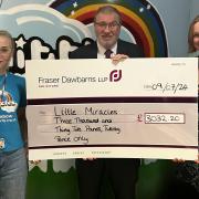 Krista Dolmane, finance manager at Little Miracles, and Neil John, partner and personal injury solicitor at Fraser Dawbarns LLP, presenting a cheque for fundraising to Louise Evans, head of income generation at Little Miracles at The Spinney.