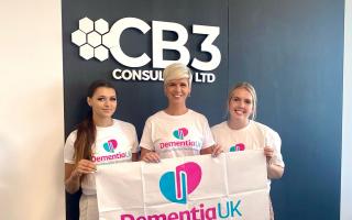 Jenny Ballantyne (centre) with her CB3 Consulting colleagues Summer Bennett (left) and Chelsea Allgood (right) holding a Dementia UK banner.